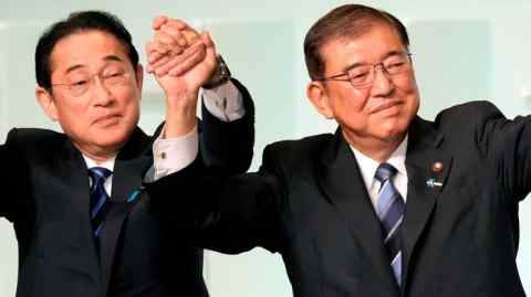 Shigeru Ishiba and Fumio Kishida raise their hands in a victory gesture after Ishiba is elected as the new head of the Liberal Democratic Party of Japan.